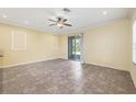 A spacious living room with tan walls, tile floor, crown moulding, recessed lighting, and a sliding glass door at 1033 Grantham Dr, Sarasota, FL 34234