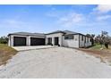 Contemporary home featuring a three-car garage and gravel driveway at 1116 406Th E Ct, Myakka City, FL 34251
