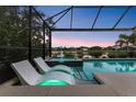Luxurious pool with spa and lounge chairs set against a picturesque lake view at dusk at 12237 Longview Lake Cir, Bradenton, FL 34211