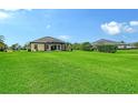 Large grassy backyard with a screened-in lanai, offering ample outdoor space and privacy at 15608 31St E St, Parrish, FL 34219