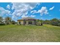 Expansive backyard featuring an enclosed patio, lush lawn and a tropical feel at 15608 31St E St, Parrish, FL 34219