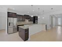 Bright and spacious kitchen features dark cabinetry, stainless steel appliances, and tile flooring at 15608 31St E St, Parrish, FL 34219