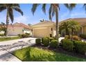 Charming one-story home with a two-car garage, tropical landscaping, and a well-maintained lawn at 27243 Ipswich Dr, Englewood, FL 34223