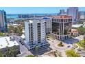 Aerial view of a modern, white condo building showcasing its surrounding urban landscape at 300 S Pineapple Ave # 302, Sarasota, FL 34236