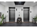 Elevator lobby with a modern wood block accent piece, tile floors, and planters at 300 S Pineapple Ave # 302, Sarasota, FL 34236