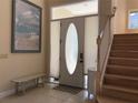 Bright entryway featuring a decorative front door, stairs, and neutral tile flooring at 3405 54Th W Dr # 104, Bradenton, FL 34210