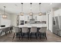 Modern kitchen featuring a large center island, pendant lighting, and stainless steel appliances at 3415 Big Sky Way, Bradenton, FL 34211