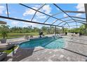 Screened-in pool area with a built-in spa and a tranquil view of the water at 3415 Big Sky Way, Bradenton, FL 34211