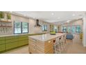 Modern, open-concept kitchen featuring a large island with seating and updated appliances at 3605 Quail Hollow Ln, Bradenton, FL 34210