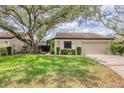 Attractive single-story home featuring a well-manicured lawn, mature trees and two-car garage at 3955 Glen Oaks Manor Dr, Sarasota, FL 34232