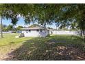 View of the home's backyard featuring a grass lawn and partial tree cover at 4229 Alna Way, Sarasota, FL 34232