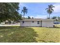 Expansive backyard with lush lawn, trees and a view of the single story home at 4229 Alna Way, Sarasota, FL 34232