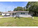 Cozy one-story home with carport, front lawn and mature trees in a suburban setting at 4229 Alna Way, Sarasota, FL 34232