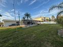Expansive backyard with mature palm trees, lush green grass, and screen enclosed pool area at 4411 Dolphin Ln, Palmetto, FL 34221