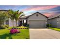 Charming single-Gathering home with a well-manicured lawn, complemented by a vibrant palm tree and flower bed at 4722 Lindever Ln, Palmetto, FL 34221