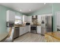 Modern kitchen featuring white cabinets, stainless steel appliances, and a stylish backsplash at 5209 Lansdowne Way, Palmetto, FL 34221