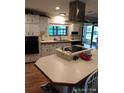 Bright kitchen features white cabinets and an island cooktop at 6357 Partridge Ave, Englewood, FL 34224