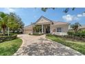 Inviting single-story home with a red tile roof, arched entryway, and lush landscaping at 6633 The Masters Ave, Lakewood Ranch, FL 34202