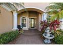 Elegant front entrance with decorative fountain, columns, and meticulously maintained landscaping at 6951 Scrub Jay Dr, Sarasota, FL 34241