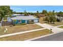 Charming blue single-story home with a well-kept lawn and attached garage at 7055 Kenwood Dr, North Port, FL 34287