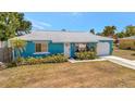Charming blue single-story home with a well-kept lawn and attached garage at 7055 Kenwood Dr, North Port, FL 34287