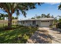 Charming single-story home with well-maintained lawn, lush landscaping, and an attached two-car garage at 709 84Th Nw St, Bradenton, FL 34209
