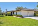 Charming home with an attached two-car garage, manicured lawn, and green landscaping at 7374 Royal Birkdale Dr # 15D, Sarasota, FL 34238