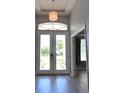 Bright entryway featuring double doors, transom window, and decorative light fixture at 8121 Snowy Egret Pl, Bradenton, FL 34202