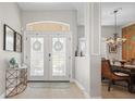 Inviting foyer features double doors, light wood flooring, and an elegant chandelier over the dining area at 9012 Province St, Sarasota, FL 34240