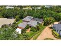 An aerial view of a home with a screened pool, lush landscaping, and an attached guest house at 9915 Old Hyde Park Pl, Bradenton, FL 34202
