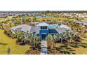 Aerial view of the community clubhouse, pool, and surrounding landscape in a residential neighborhood at 10708 Tippecanoe Pl, Parrish, FL 34219
