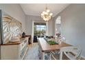 Bright dining room featuring a chandelier, a wooden table with white chairs, and an elegant accent wall at 11 Lateen Sail Dr, Placida, FL 33946
