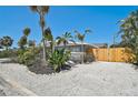 Attractive single-story home featuring lush landscaping, tall palm trees, and a fenced-in yard at 1112 65Th Nw St, Bradenton, FL 34209