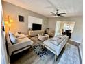 Bright living room featuring modern furnishings, a ceiling fan, and an open view to the dining area at 1112 65Th Nw St, Bradenton, FL 34209
