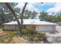 Beautiful home featuring a well-manicured lawn, metal roof and attached two car garage at 1130 Mill Creek Rd, Bradenton, FL 34212