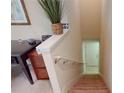 Interior view of a carpeted staircase with a decorative plant on the landing and a partial view of a desk at 116 Navigation Cir # 106, Osprey, FL 34229