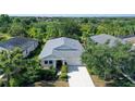 An aerial front view of a single-story home showing the yard, driveway and landscaping at 12133 Forest Park Cir, Bradenton, FL 34211