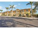 Two-story townhomes with tropical landscaping and sunny yellow exterior paint at 12358 Destiny Dr, Venice, FL 34292