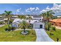 Inviting home with lush lawn, palm trees, and a well-maintained exterior, including a two car garage and solar panels at 127 Colonial Sw St, Port Charlotte, FL 33952