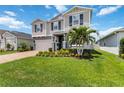 Attractive two-story home with lush lawn, palm tree, and inviting curb appeal at 14363 59Th E Cir, Lakewood Ranch, FL 34211
