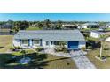 Aerial view of a cozy single-story home with a well-kept lawn, blue shutters, and a long driveway at 18082 Eau Gallie S Cir, Port Charlotte, FL 33948