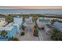 Aerial view of a luxurious beach house with multiple decks overlooking the ocean, surrounded by pristine beaches at 216 Tenacity Ln, Sarasota, FL 34242