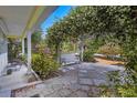 Charming front porch with swing bench and artistic stone tiled walkway at 2165 Lemon Ave, Englewood, FL 34223