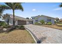 Paver driveway leading to a home with a two-car garage, landscaped yard, and modern architecture at 238 Lookout Point Dr, Osprey, FL 34229