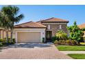Charming single-story home featuring a tile roof, stone accents, a two-car garage and meticulous landscaping at 2525 Vaccaro Dr, Sarasota, FL 34231