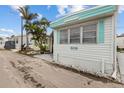 Exterior shot of home with light blue trim, siding and lush tropical landscaping at 2601 Gulf N Dr # 317, Bradenton Beach, FL 34217