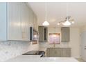 Bright kitchen featuring modern backsplash, counter tops, updated cabinets and stainless steel appliances at 301 89Th Ne Ave, St Petersburg, FL 33702