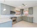 Well-lit kitchen with sleek countertops, stainless steel appliances, custom cabinets and a backsplash at 301 89Th Ne Ave, St Petersburg, FL 33702