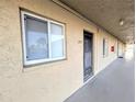 Exterior view of unit 204 showing the front door, window with blinds, and walkway to the unit at 3559 Lake Bayshore Dr # J-204, Bradenton, FL 34205