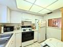 An efficient kitchen features standard appliances, including a refrigerator and range, along with ample counter space at 3559 Lake Bayshore Dr # J-204, Bradenton, FL 34205
